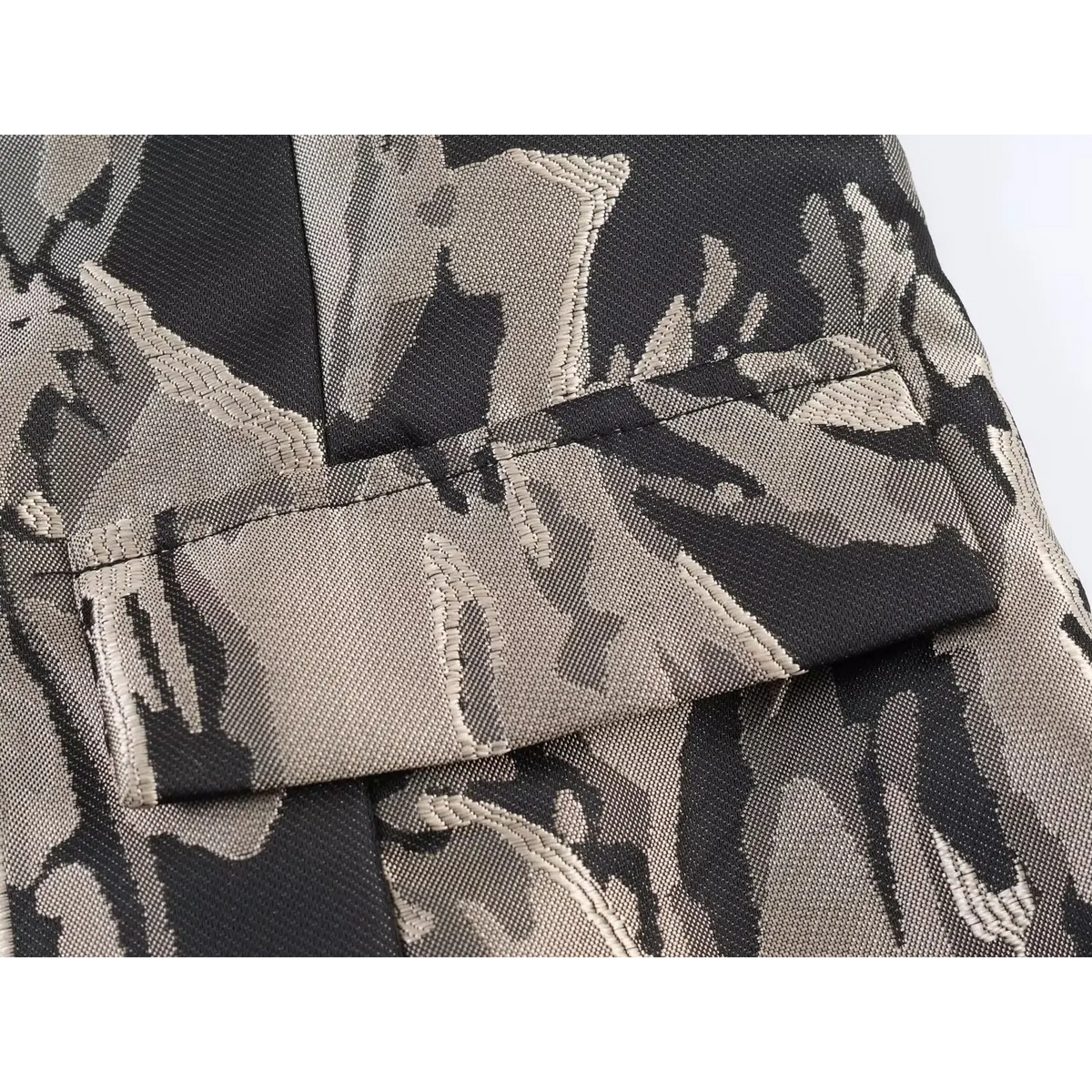 Close-up of faux flap pocket at waist on black grey floral jacquard mini dress, woven pattern and neat stitching