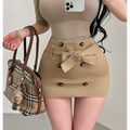 Lifestyle model selfie shot khaki high waist mini skirt, matching fabric bow tie belt, double row dark button detail, slim bodycon silhouette, business casual outfit match with beige short sleeve top
