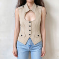Model wearing khaki sleeveless tailored waistcoat, pointed collar, chest cutout design, black front buttons and flap pockets, fitted cropped silhouette, front view