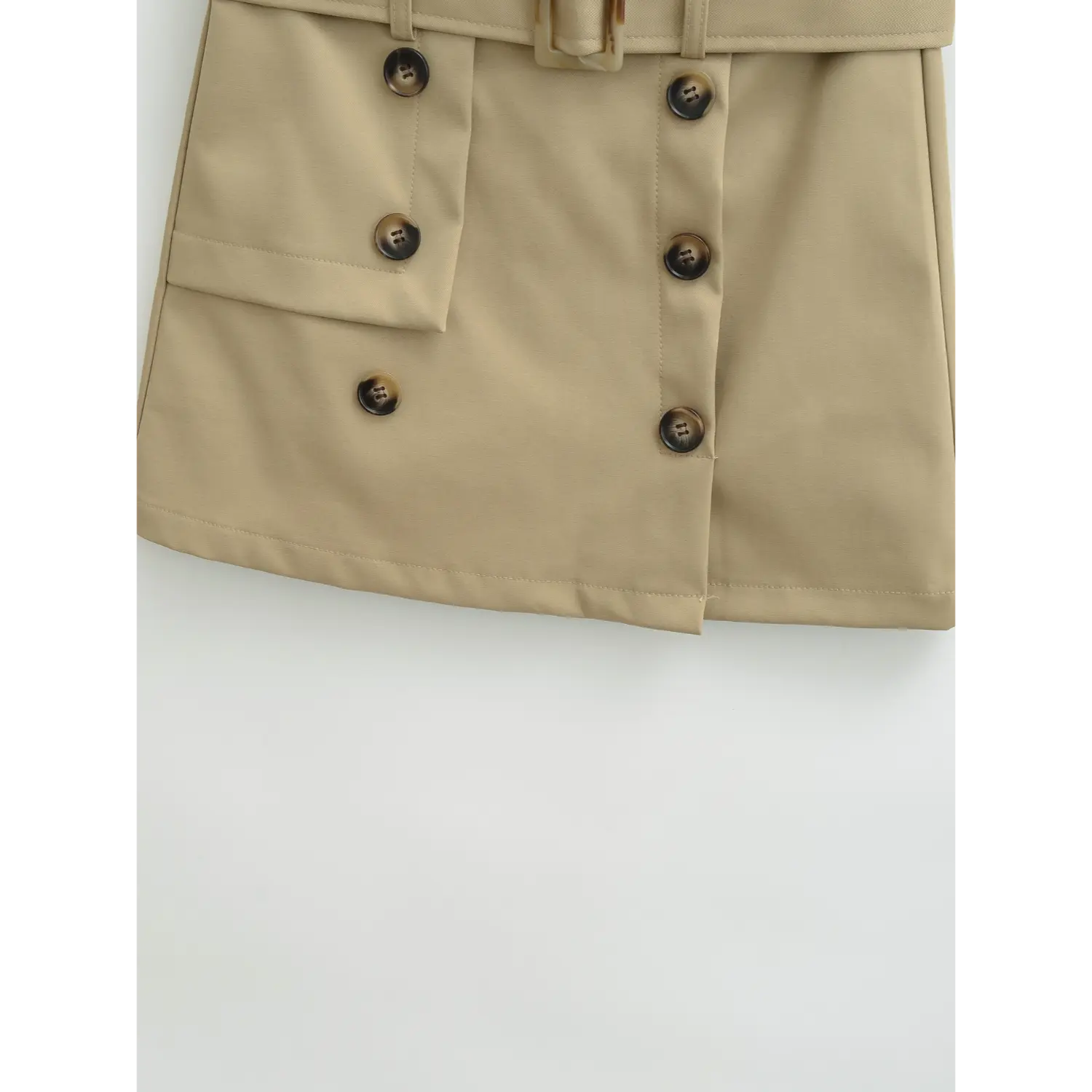 Khaki workwear mini skirt front hem flat close-up, asymmetrical double gradient horn buttons fake placket split cut neat overlock a-line hem stiff suit twill white background shot
