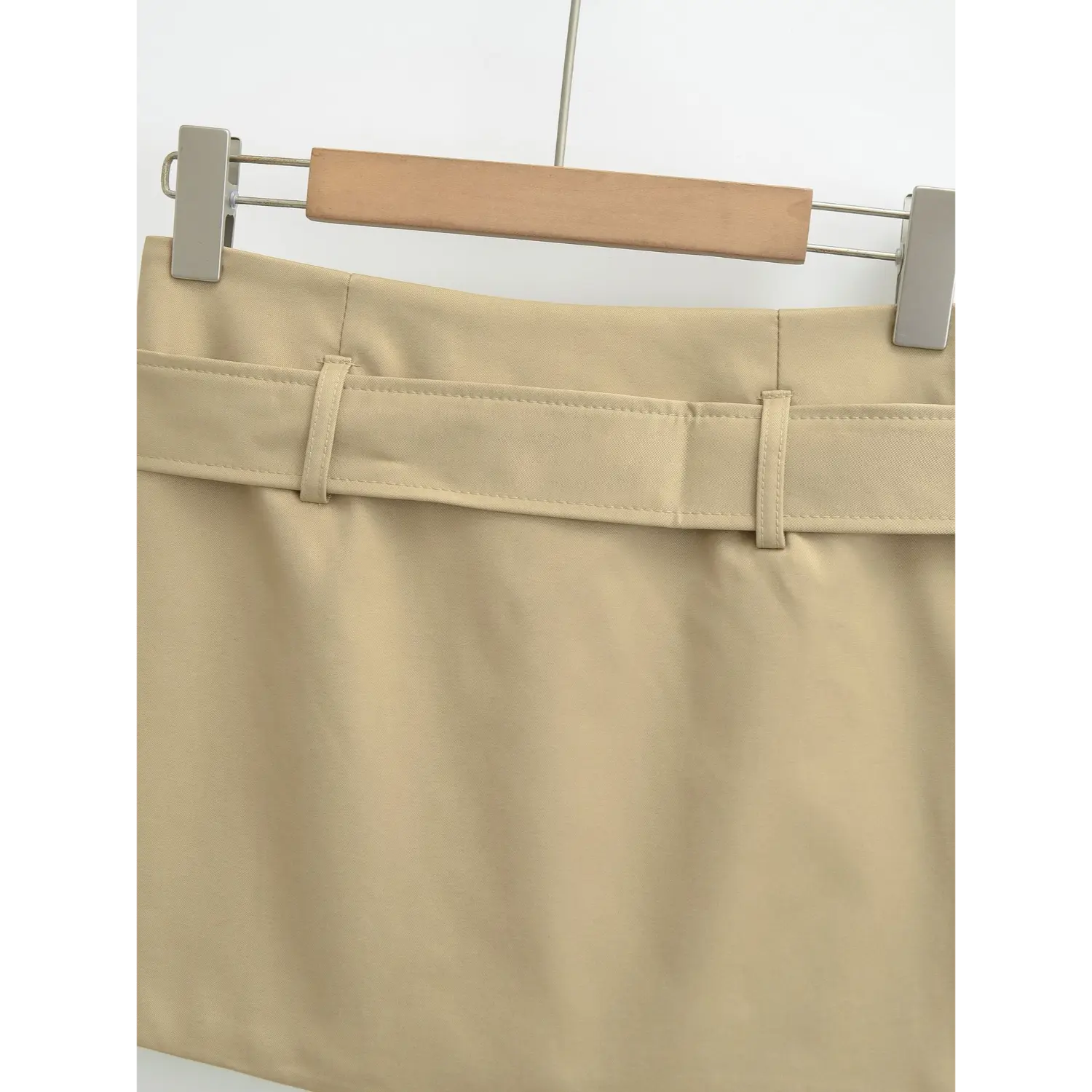 Khaki mini skirt full back waist flat close-up, symmetrical dual belt loops one-piece smooth back waist uniform stitching waistband white background shot