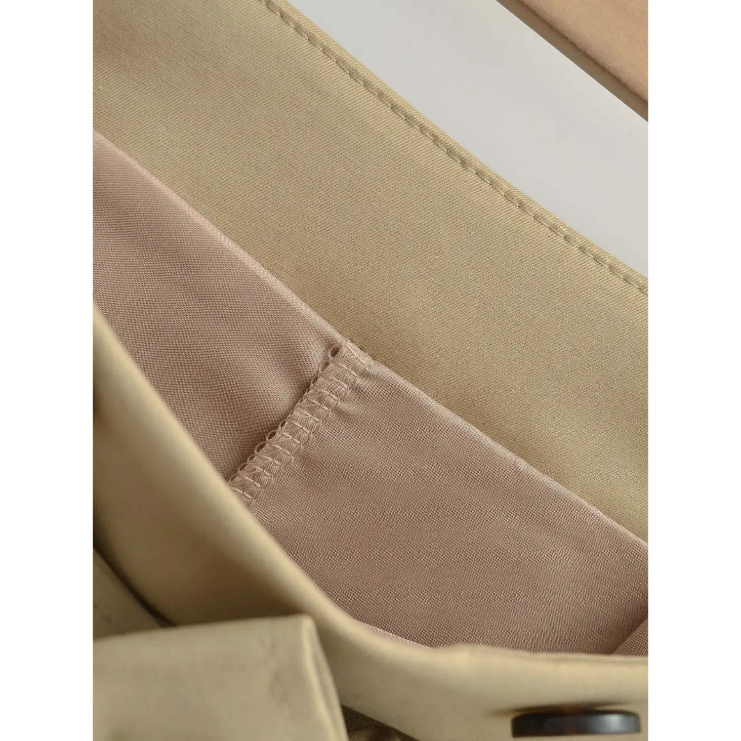 Khaki mini skirt inner lining macro flat close-up, light pink skin-friendly lining wavy elastic overlock full hem lining anti-exposure craft white background shot