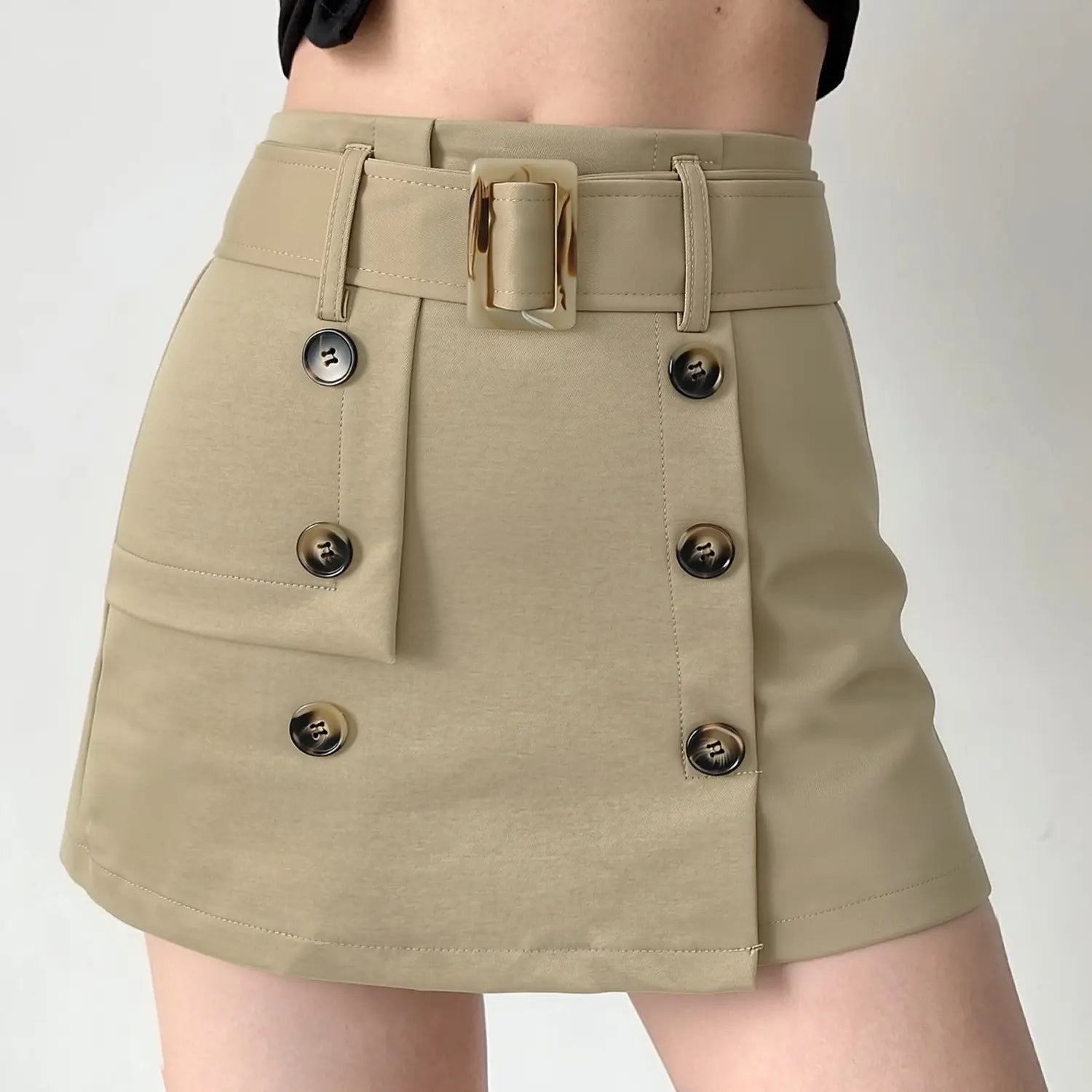 Khaki tortoise buckle belt workwear a-line mini skirt half body indoor model shot, high waist leg-lengthening cut asymmetrical double horn buttons square tortoise belt buckle matched with cropped top commuter cool girl outfit display