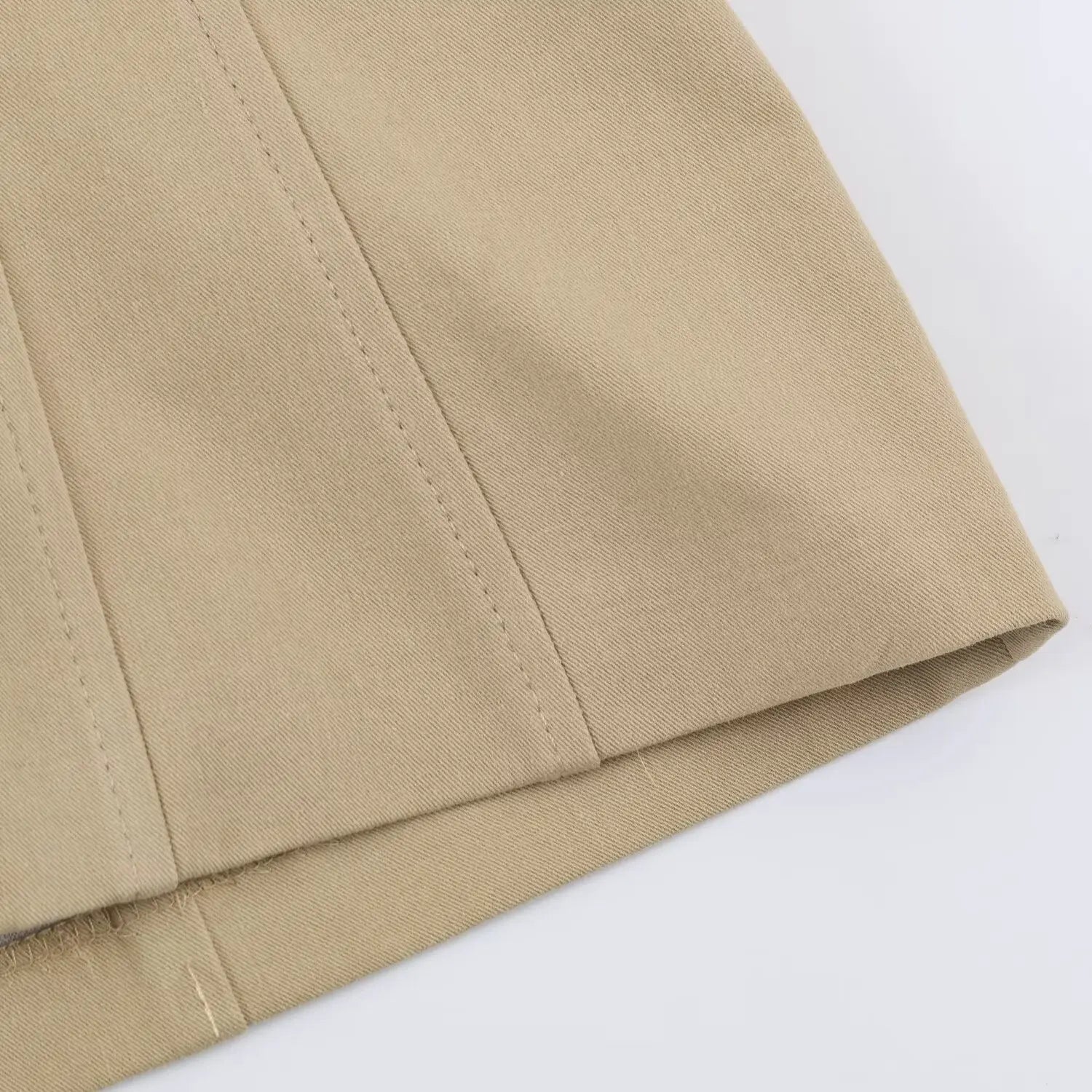 Detailed shot of structured vertical stitching and twill fabric hem on khaki bodycon mini dress