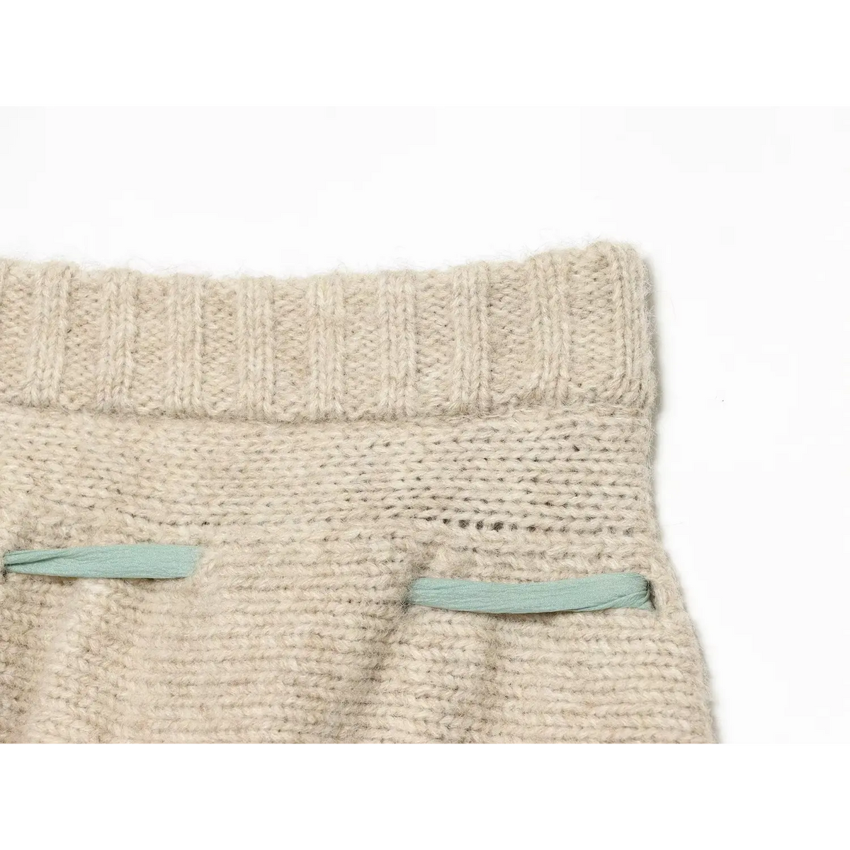 Close-up of back pocket mint green ribbon decoration and ribbed waistband on oat knit skort