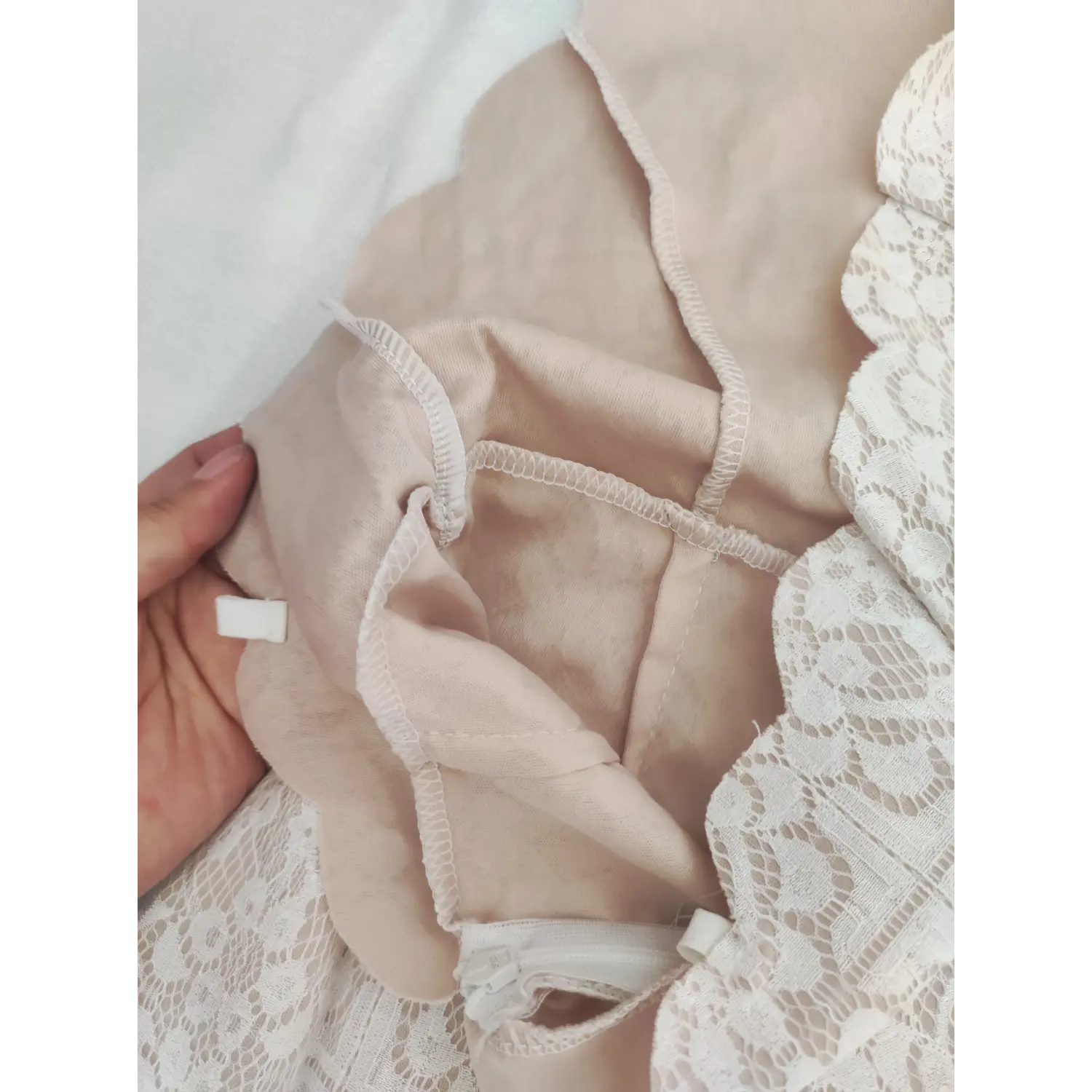Inner lining close-up, stitching detail, fabric tag and zipper interior of lace dress