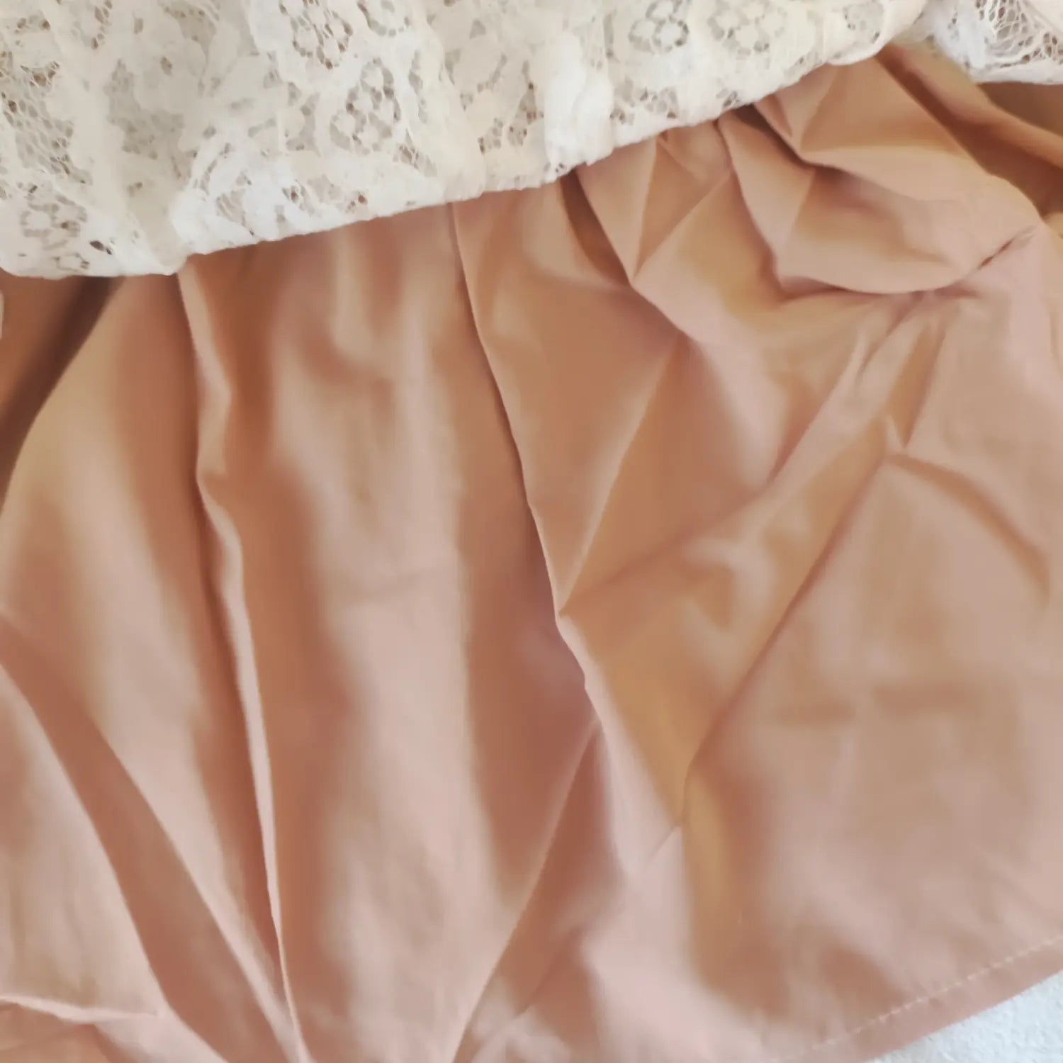 Close-up shot, soft nude inner lining fabric of white lace strapless mini dress