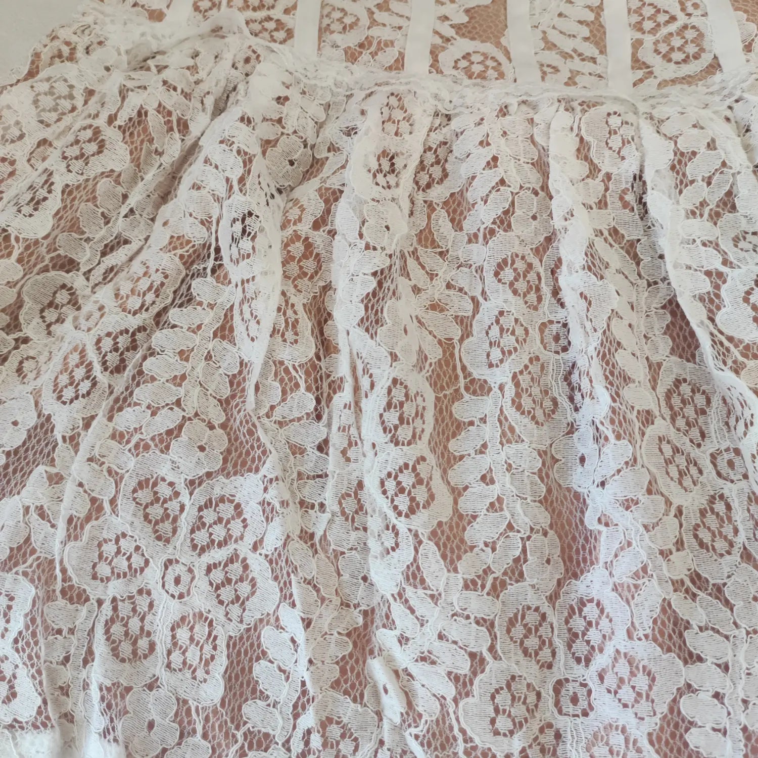 Close-up skirt view, gathered flounce hem with floral white lace fabric texture