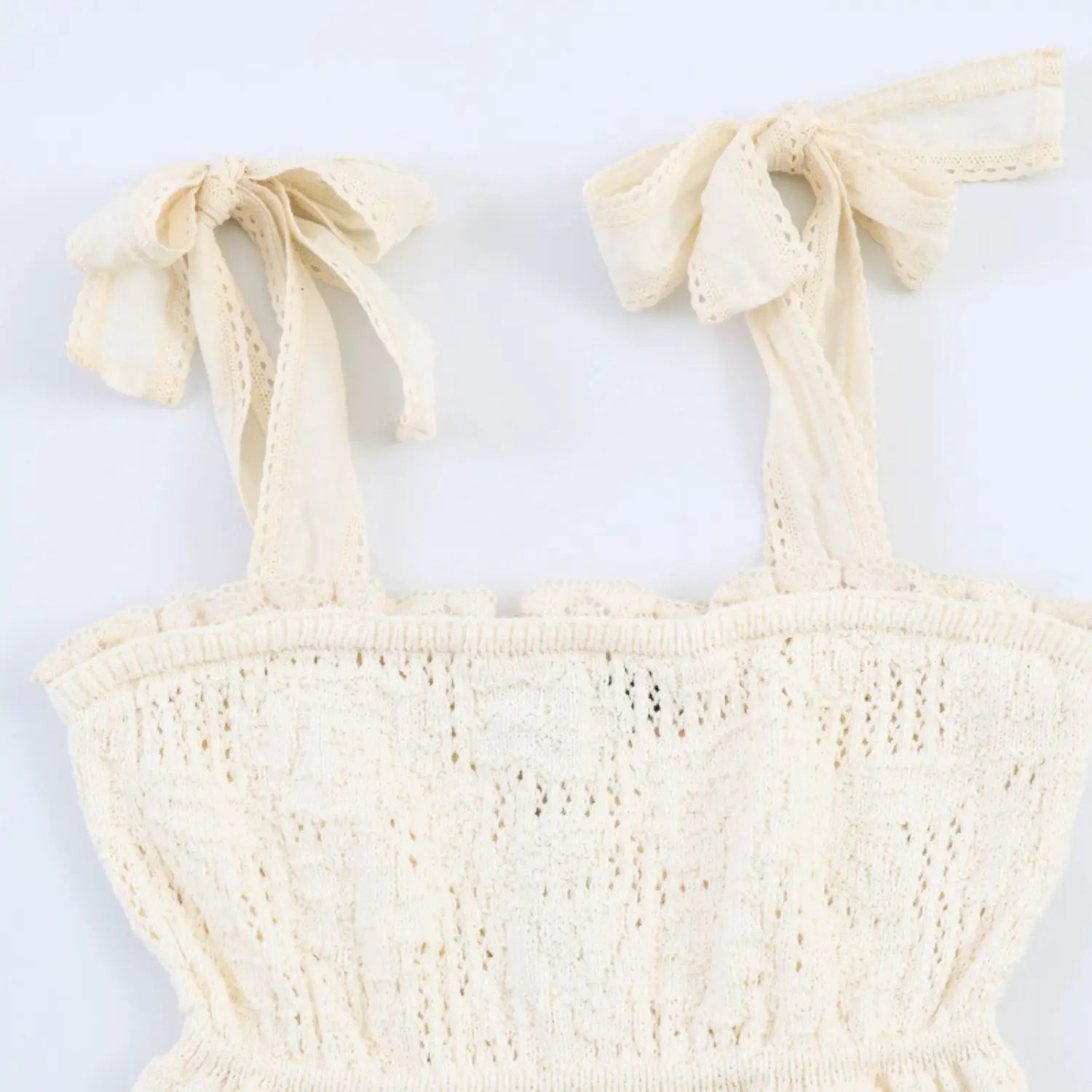 Closeup adjustable shoulder straps with scalloped lace trim & self fabric tie bow