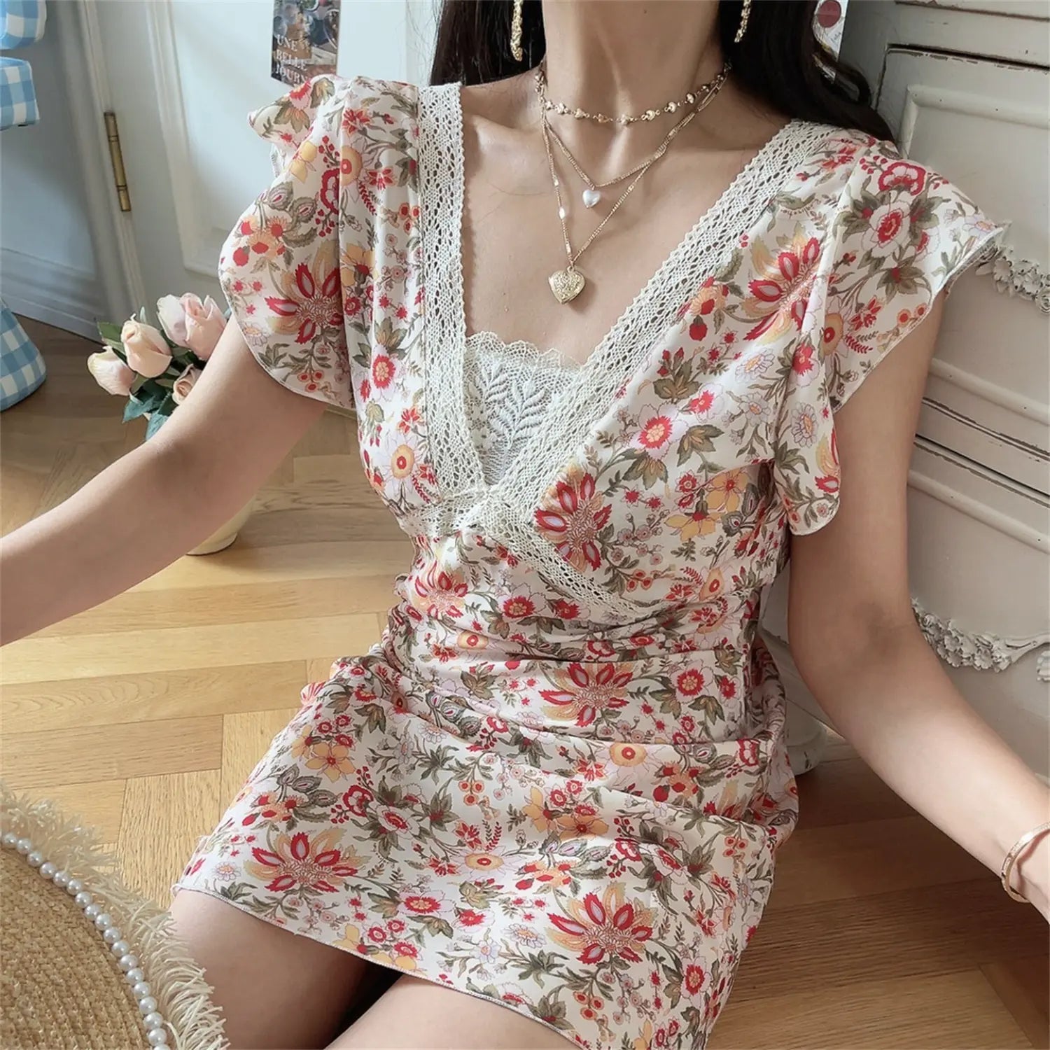 Close up lifestyle shot hollow lace wrap V neck detail, vintage mixed flower print mini dress, flutter cap sleeve casual summer outfit