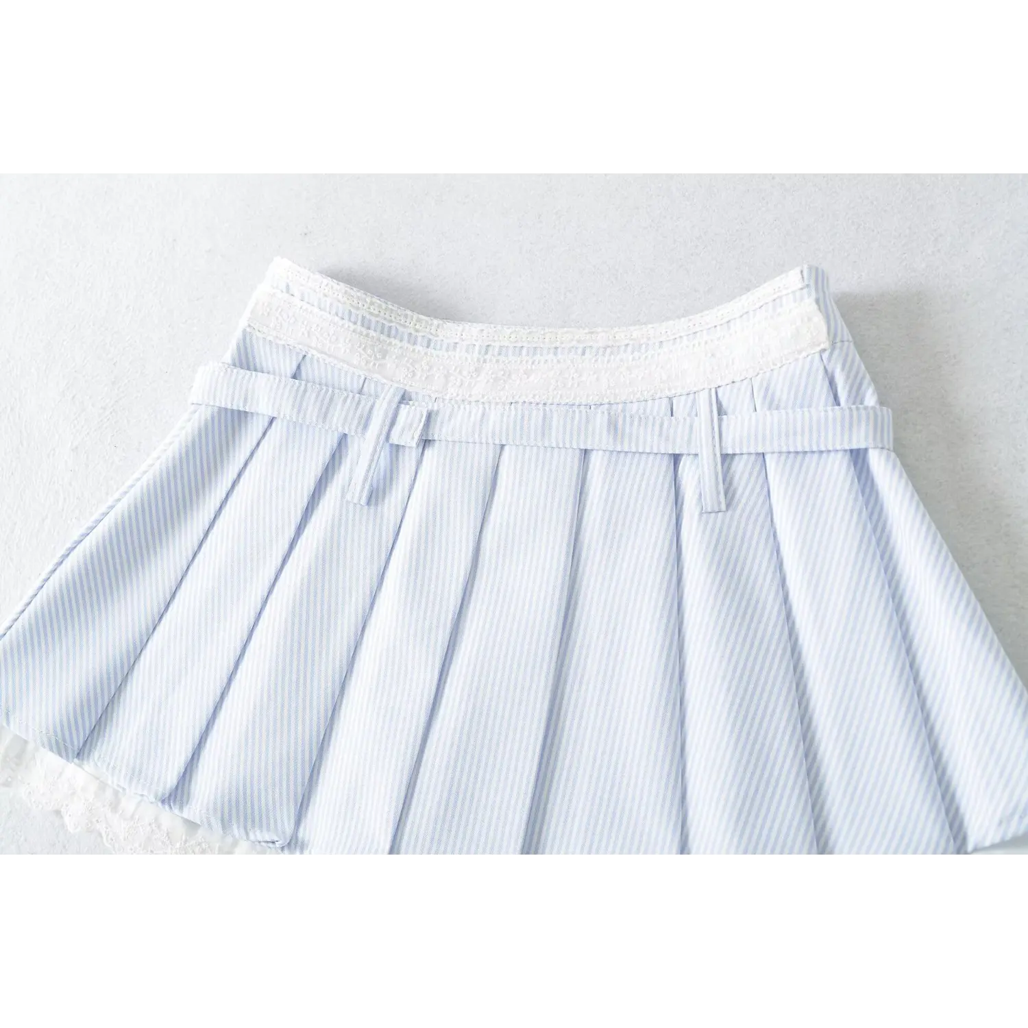 Lace trim double waistband pleated skirt flat close-up, matching stripe adjustable belt multi metal eyelets neat pressed pleats waist craft shot