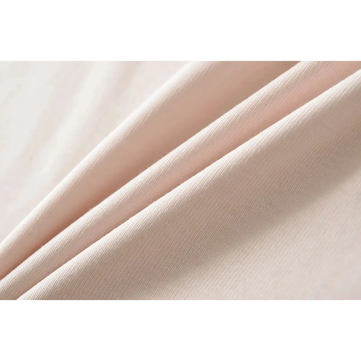 Close-up of the ribbed fabric texture on a light pink cami top, highlighting its soft and stretchy quality.