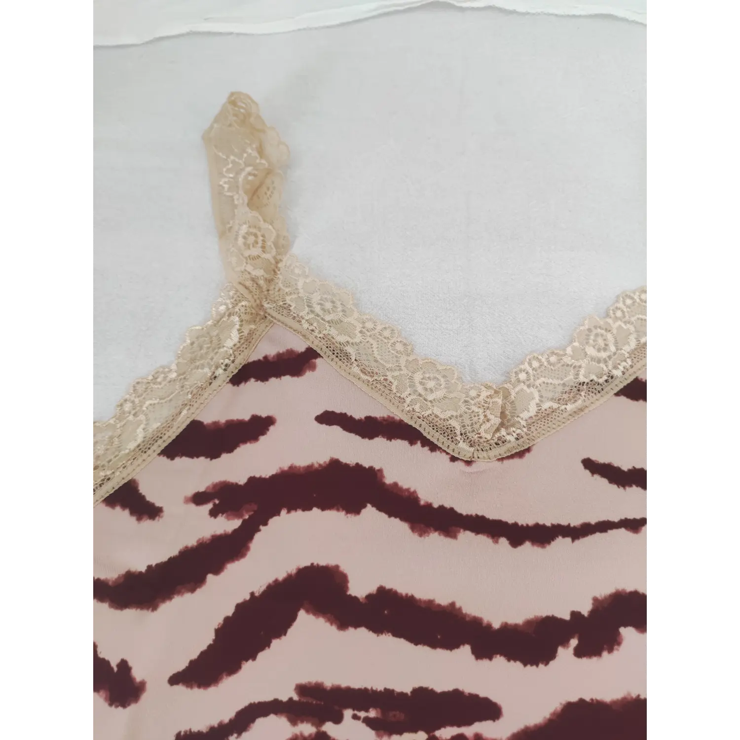 Macro view of V-neckline and lace spaghetti straps on pink tiger stripe mini dress