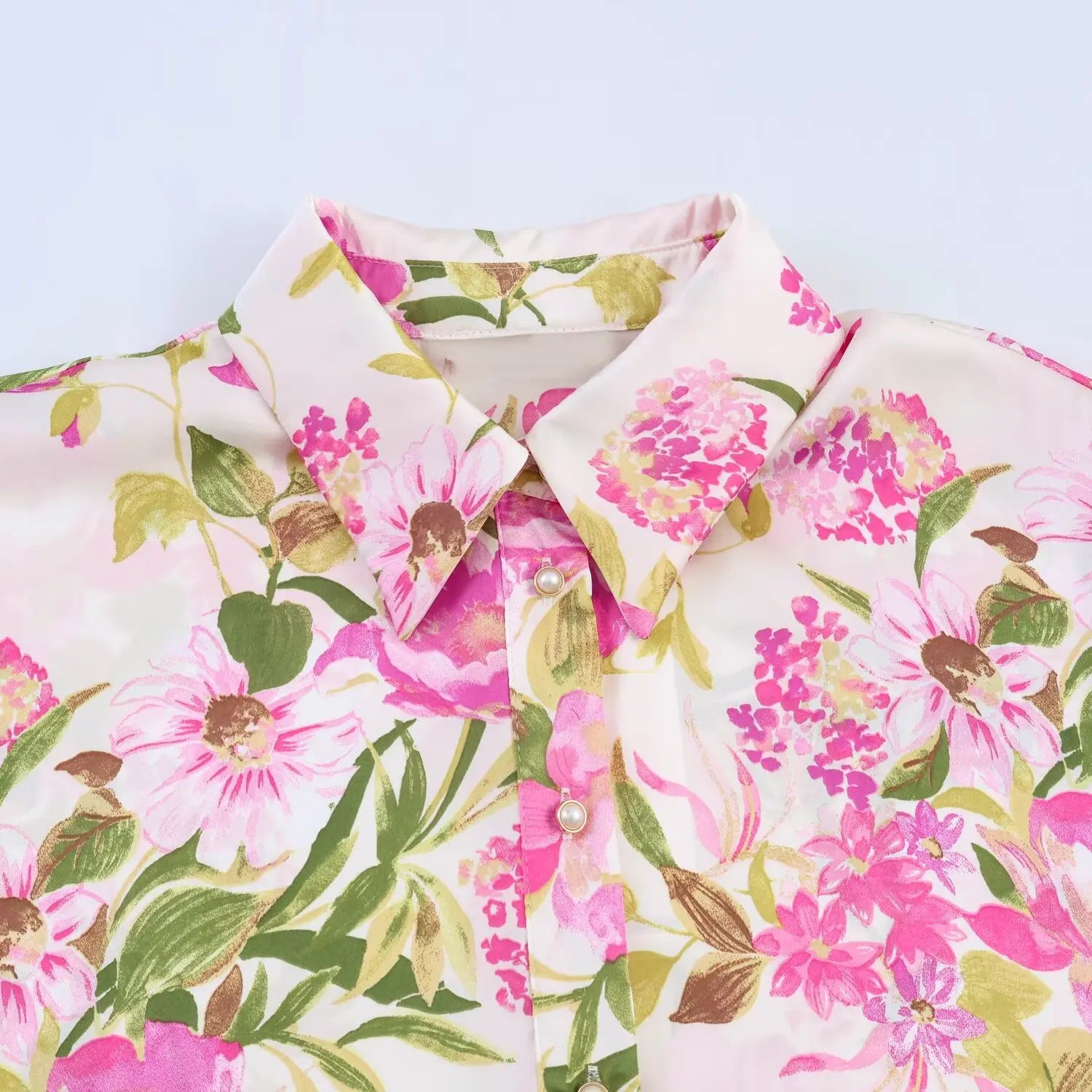 Neckline partial close-up, pointed lapel collar, gold rim pearl buttons, pink floral satin texture