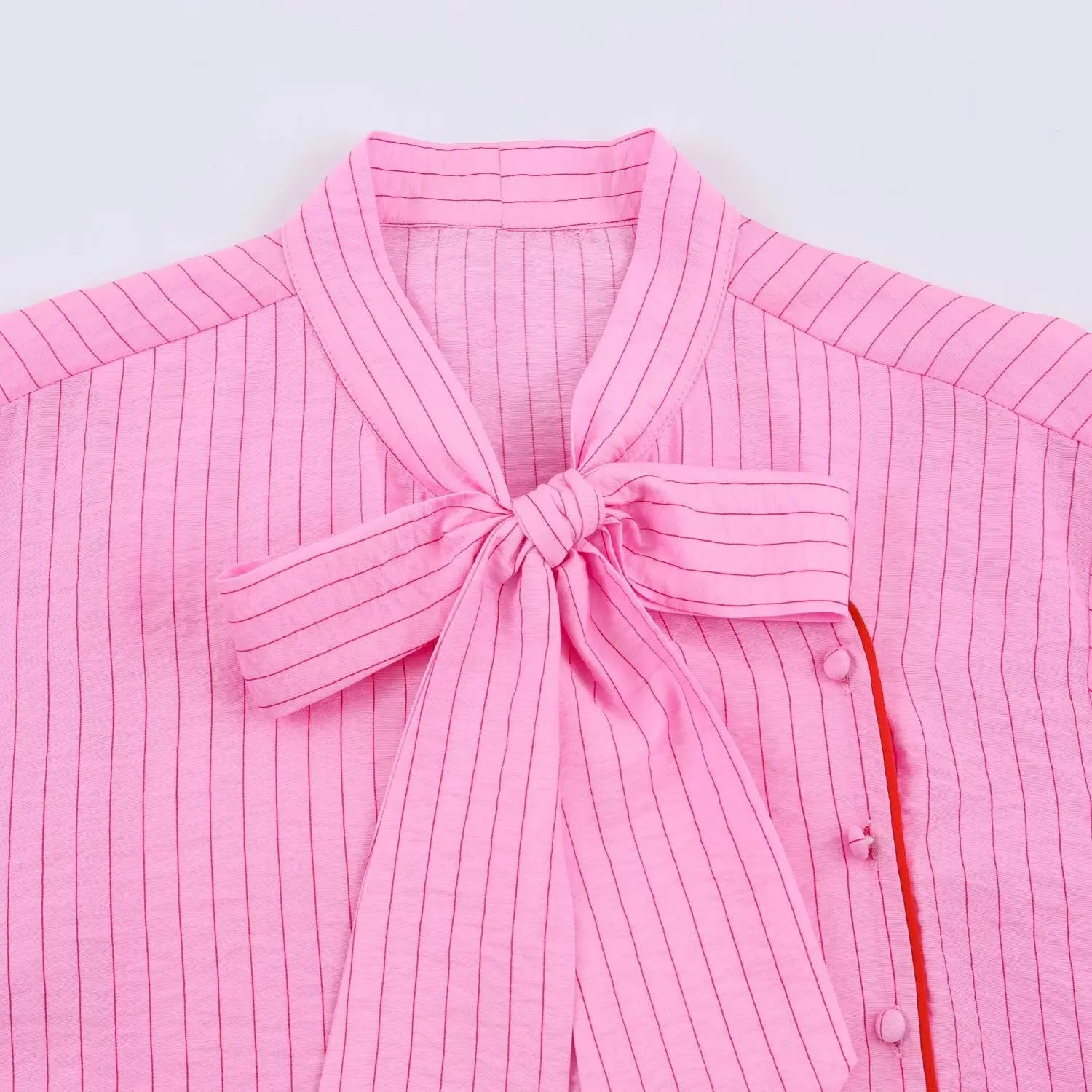 Flat closeup front stand collar, oversized matching stripe bow, asymmetrical button placket with red trim