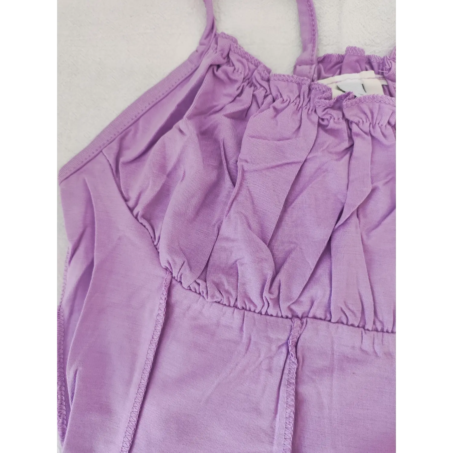 Close‑up detail of neck ruffle and bust ruched gathering stitching on lavender cami crop top