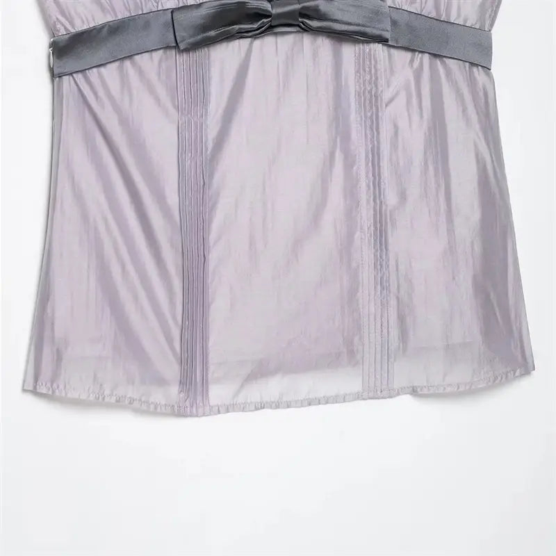 Lower front vertical pin-tuck pleat macro shot, parallel decorative stitching, wrinkled lavender fabric surface