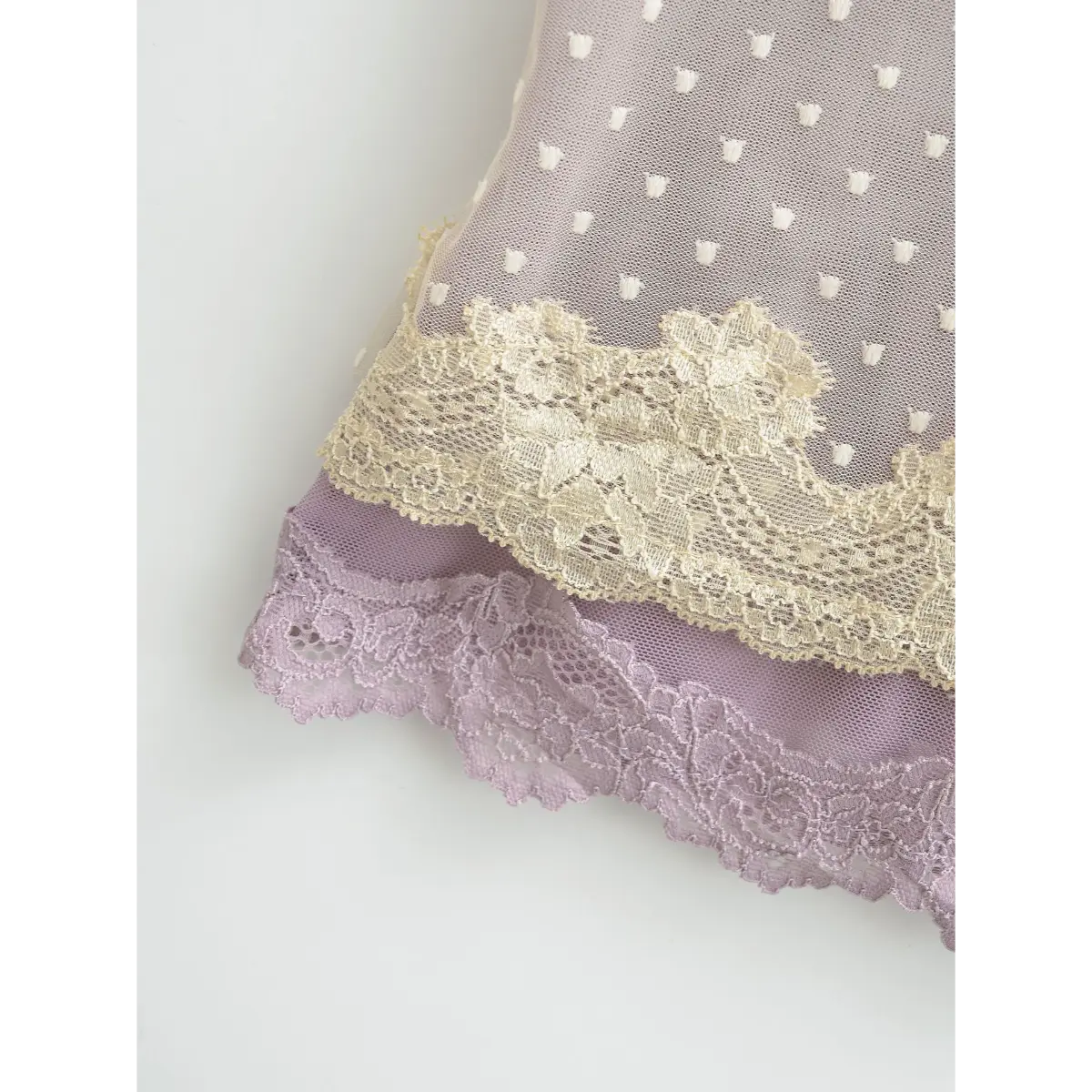Close-up of the layered lace trim and heart-patterned mesh at the hem.