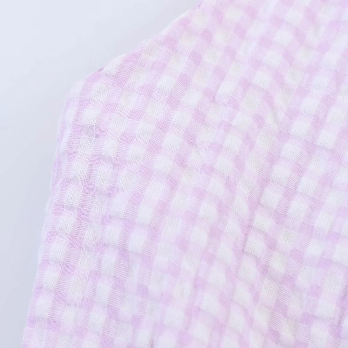 Macro shot of lavender and white gingham fabric, crinkle waffle texture, breathable summer textile