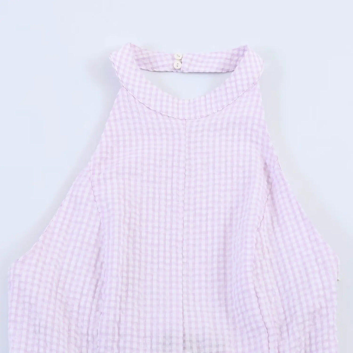 Close-up of lavender gingham halter dress neck, halter strap with button closure, textured check fabric