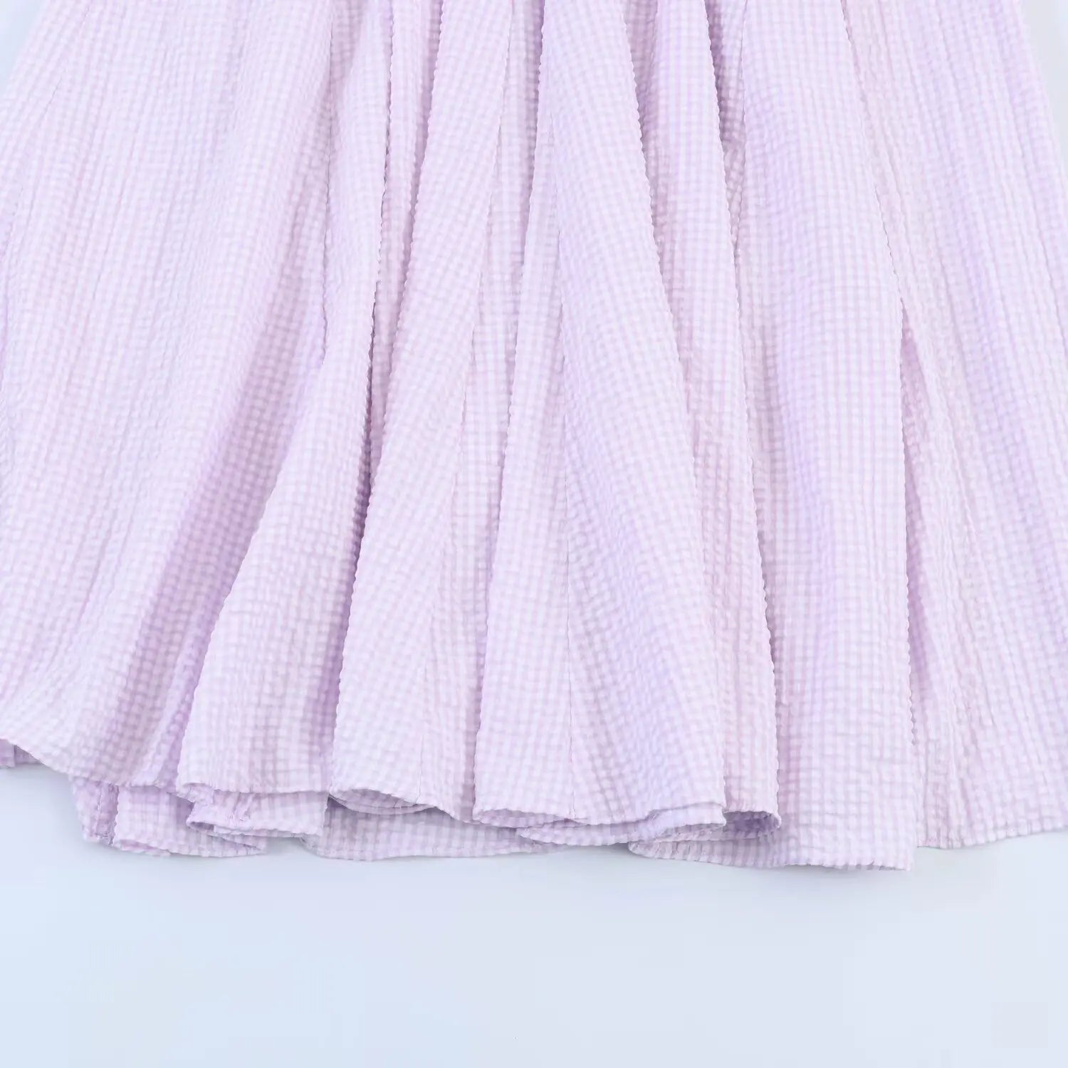 Close-up of lavender gingham maxi dress skirt, layered flared panels, lightweight crinkled fabric