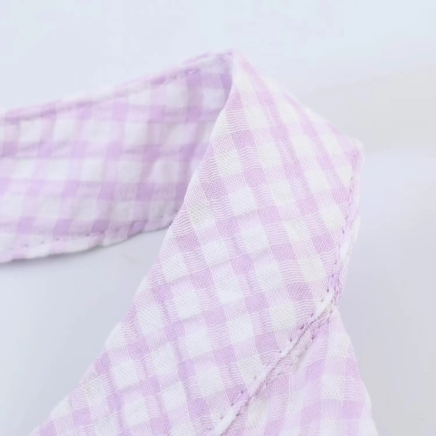 Close-up of halter strap stitching detail, lavender white gingham pattern, fine neat seams