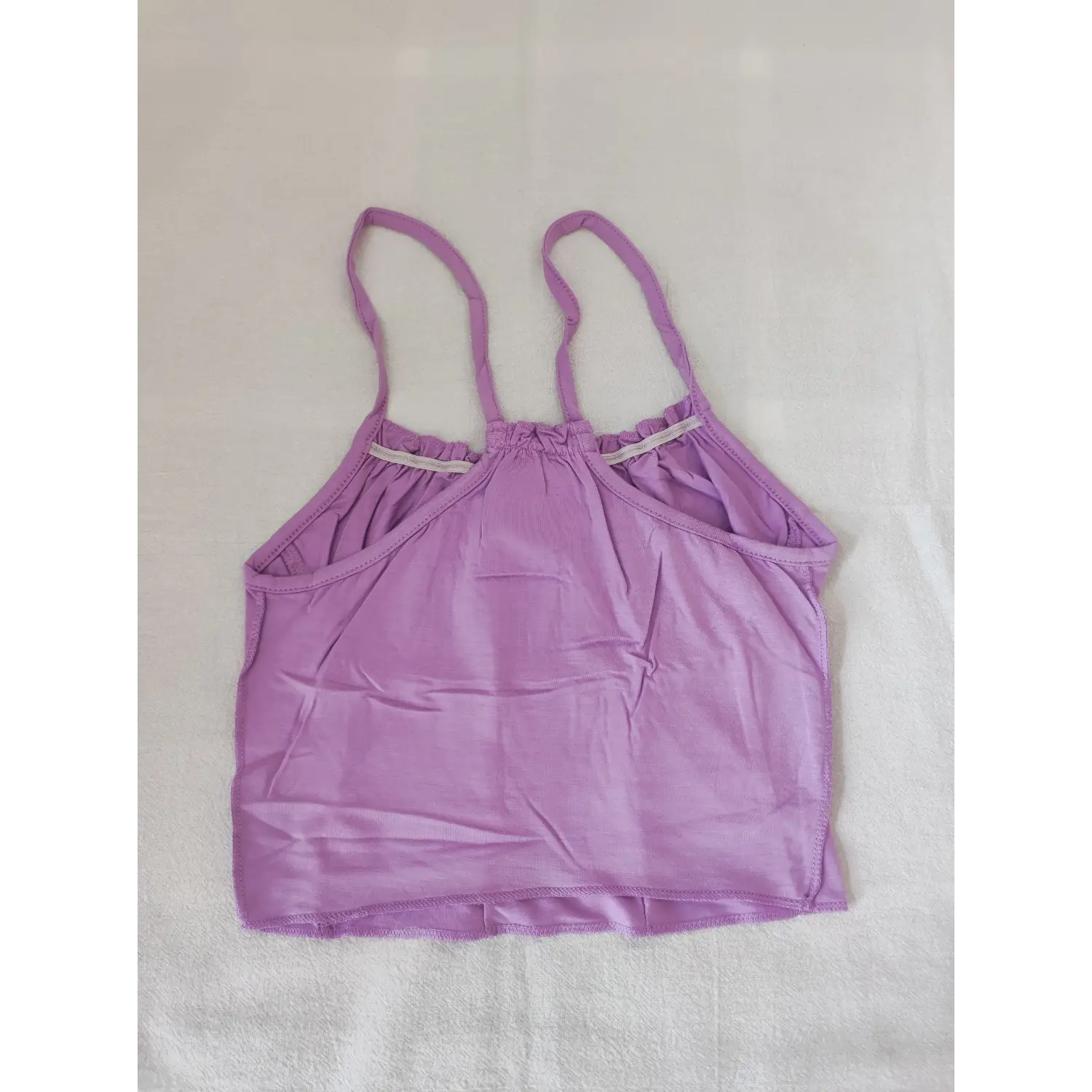 Flat lay back view lavender halter style cami crop top showing back cutout and spaghetti straps