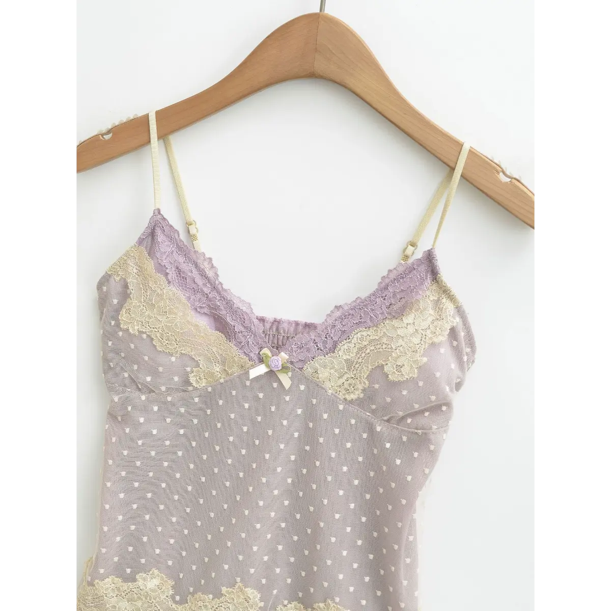 Lavender camisole on a wooden hanger, showing heart-patterned mesh and lace details.