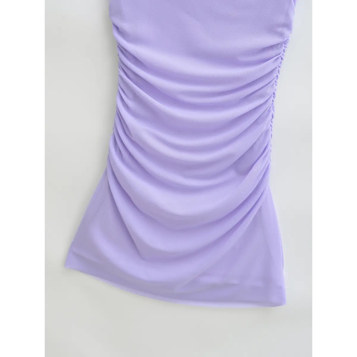 Close-up of the side ruching on the lavender mesh dress, showing gathered fabric and stretch