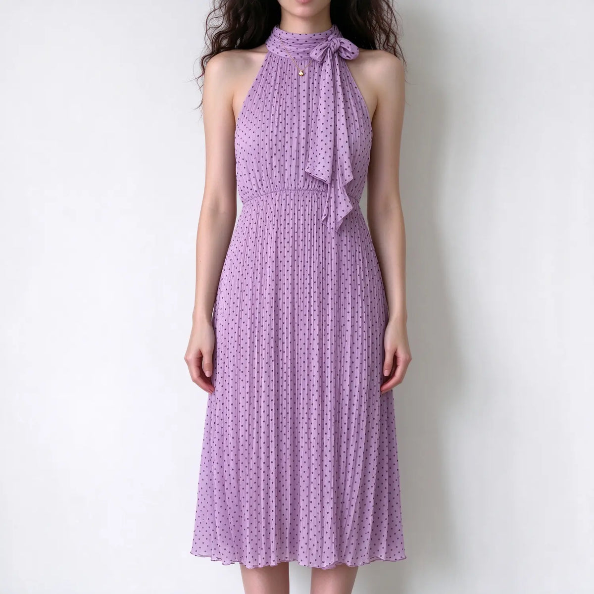 Model wearing lavender polka dot halter maxi dress, neck tie bow detail, pleated chiffon maxi dress with dark polka print, plain white background
