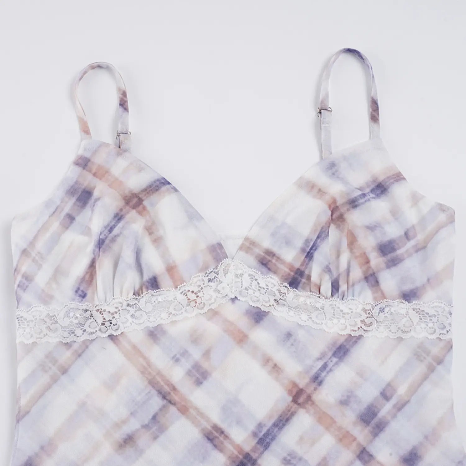 Top-down full bust flat studio shot of slip mini dress, deep V neckline, wide ornate white scalloped lace underbust band, thin adjustable matching plaid shoulder straps