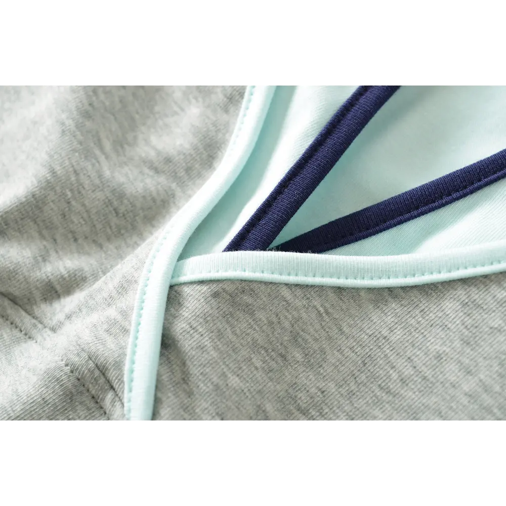 Close-up of the contrast piping and stitching at the V-neck of the gray camisole