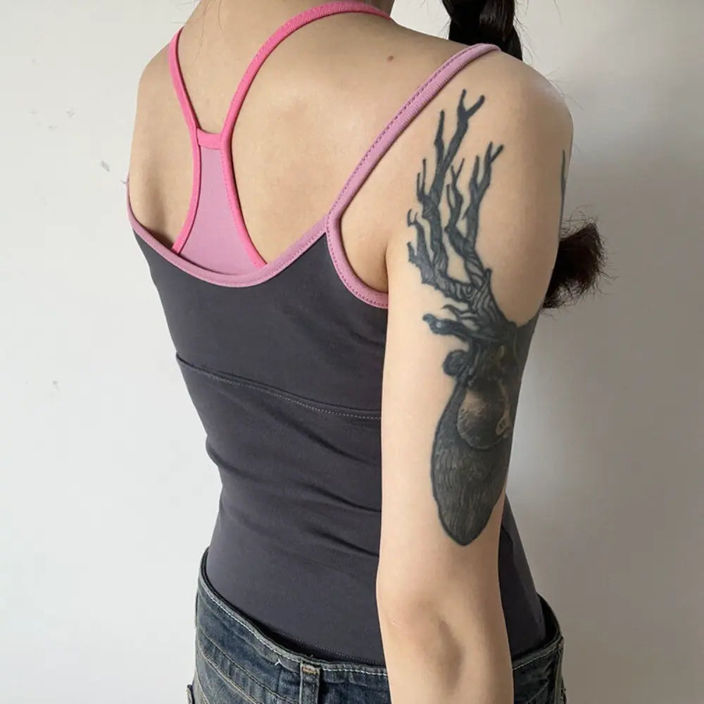 Lifestyle back view of model wearing the layered gray and pink racerback camisole top