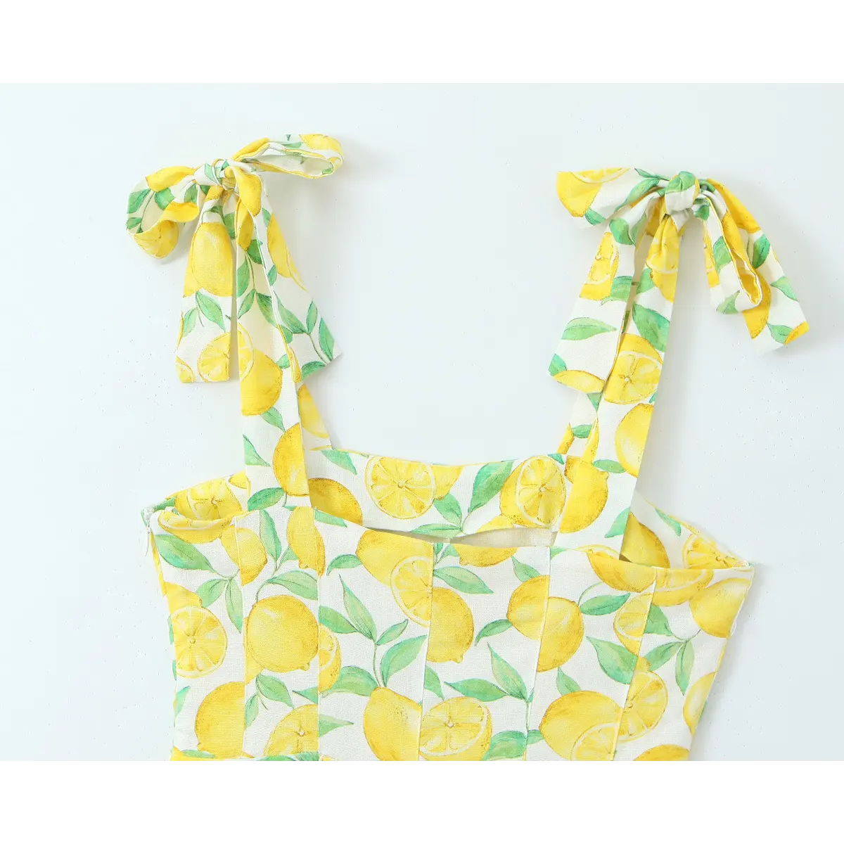 Full back view of the lemon print tie-strap dress, showing the keyhole cutout and bow details.
