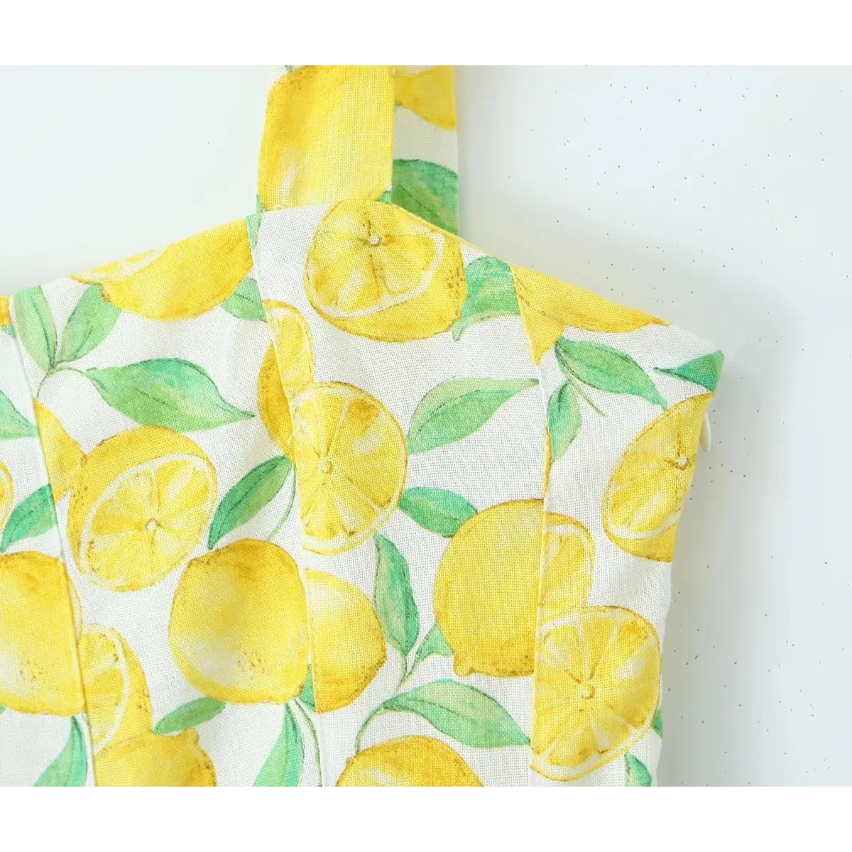 Close-up of the structured corset-style bodice on the lemon print dress.