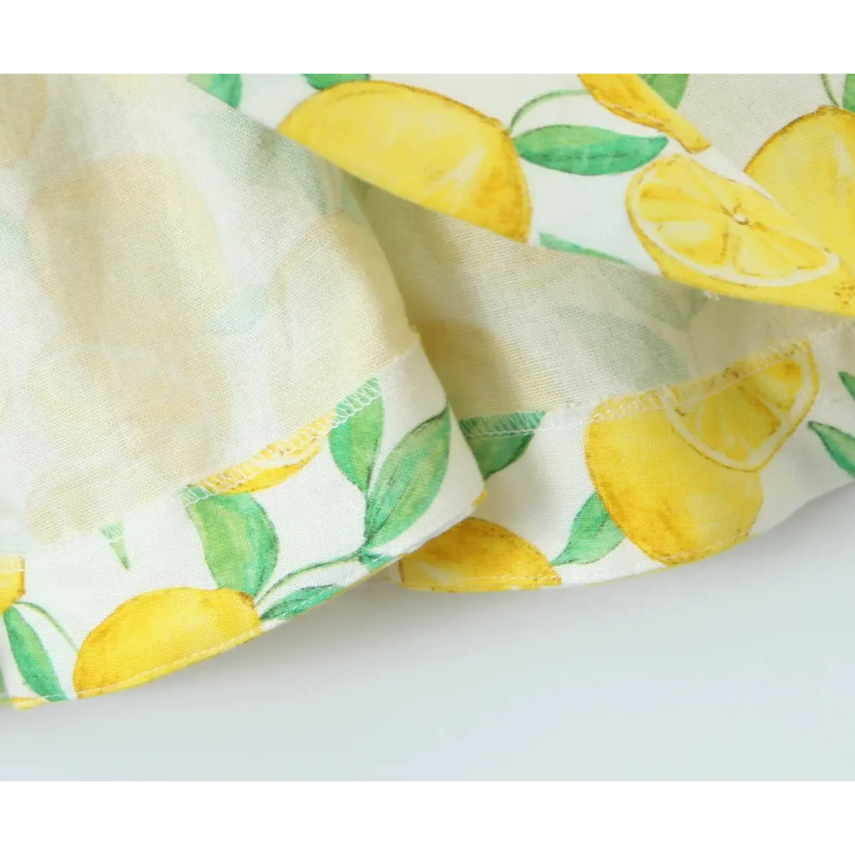 Close-up of the neatly stitched hem on the lemon print flared dress.