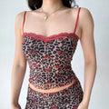 Close-up shot of mesh cami crop top, scalloped red lace neckline, adjustable thin straps, leopard cherry allover print, wavy lettuce hem