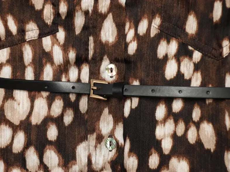 Macro close-up of black leather belt and buttons