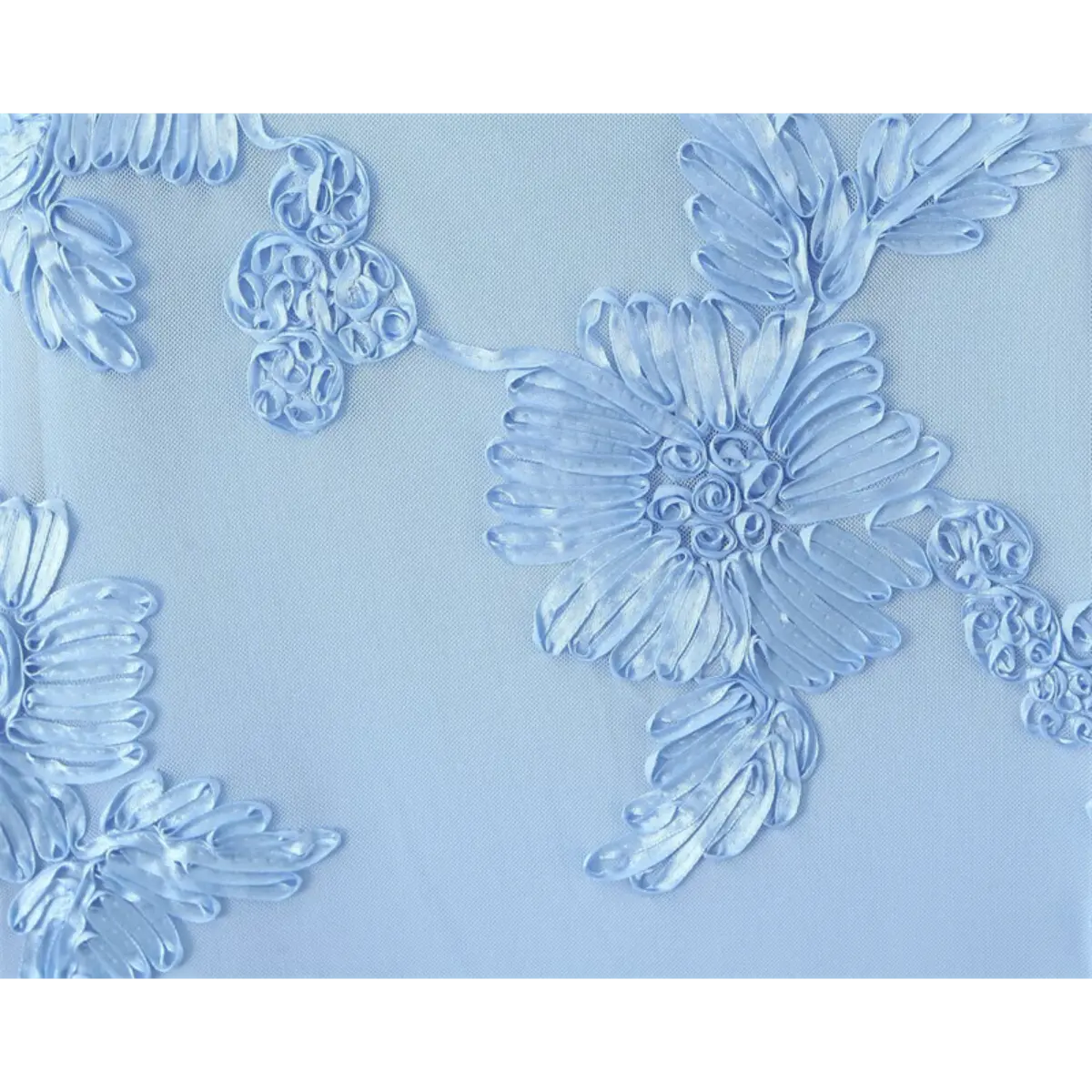 Close-up of the 3D floral embroidery on a light blue gown, highlighting the ribbonwork texture and mesh base.