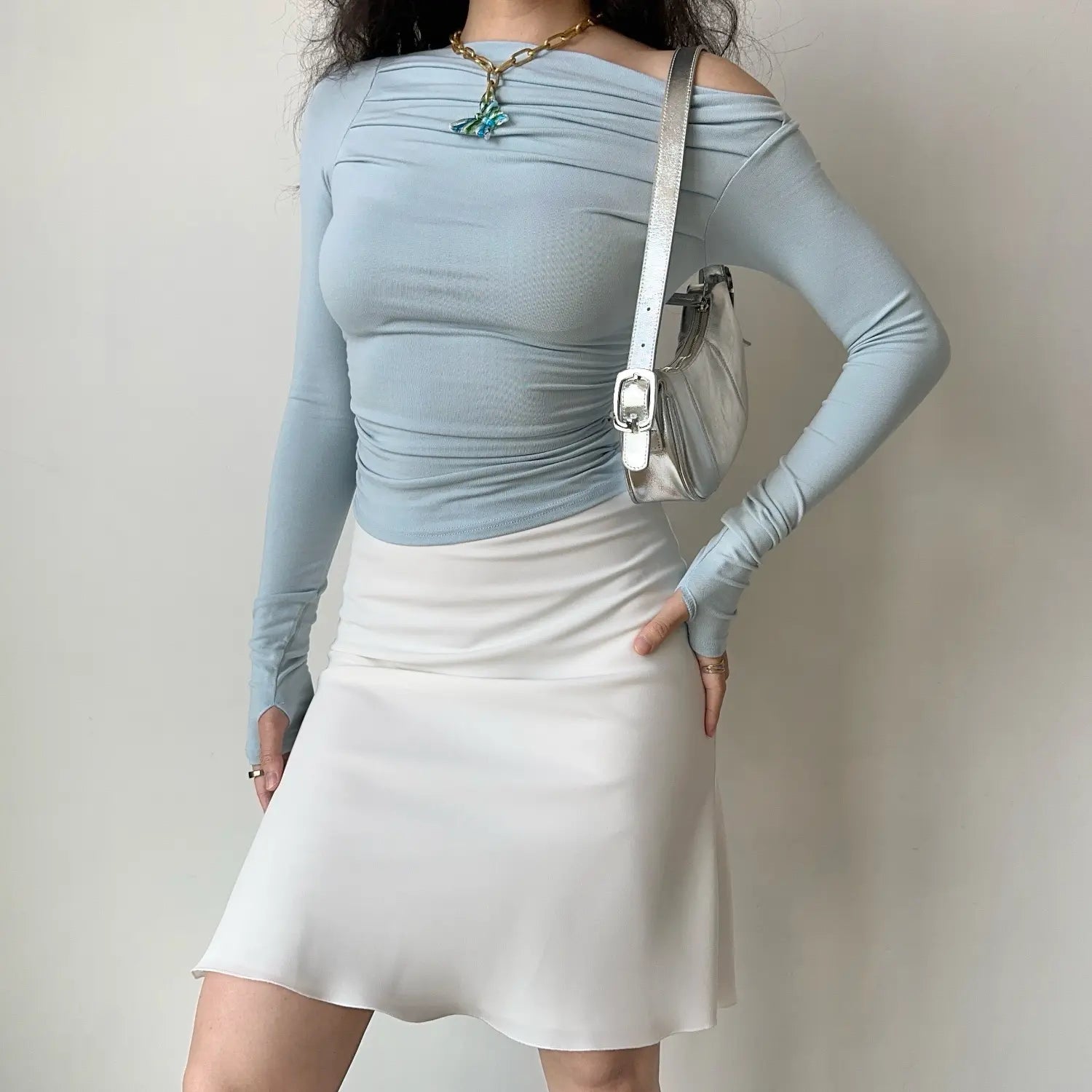 Full model shot light blue asymmetry off‑shoulder long sleeve crop top draped ruched detail thumb hole slim fitted top