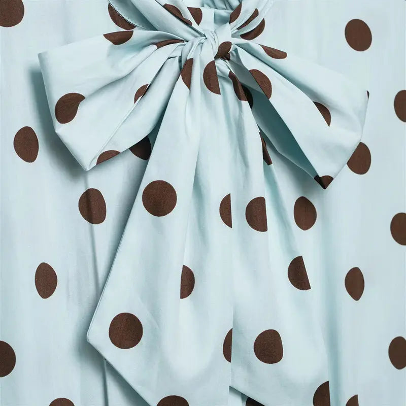 Macro closeup large self fabric bow tie at neck, layered long ribbon tails, matching dot print