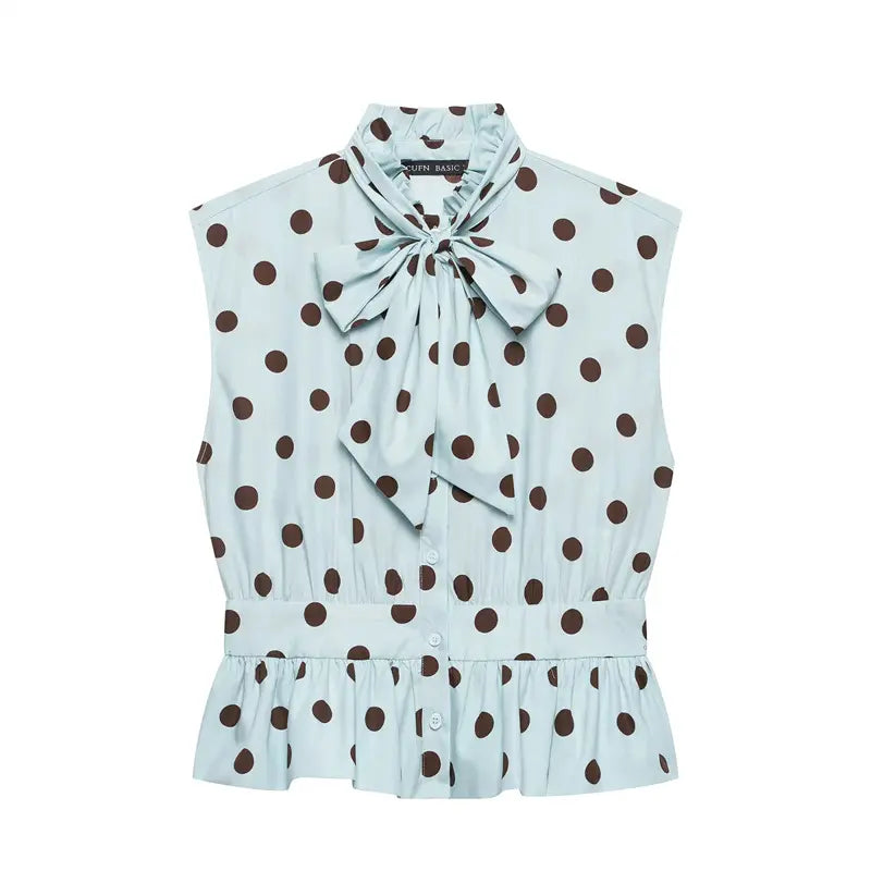Front flat lay product shot light blue sleeveless blouse, big brown polka dot print, neck self tie bow, smocked waist, ruffle hem, front button placket