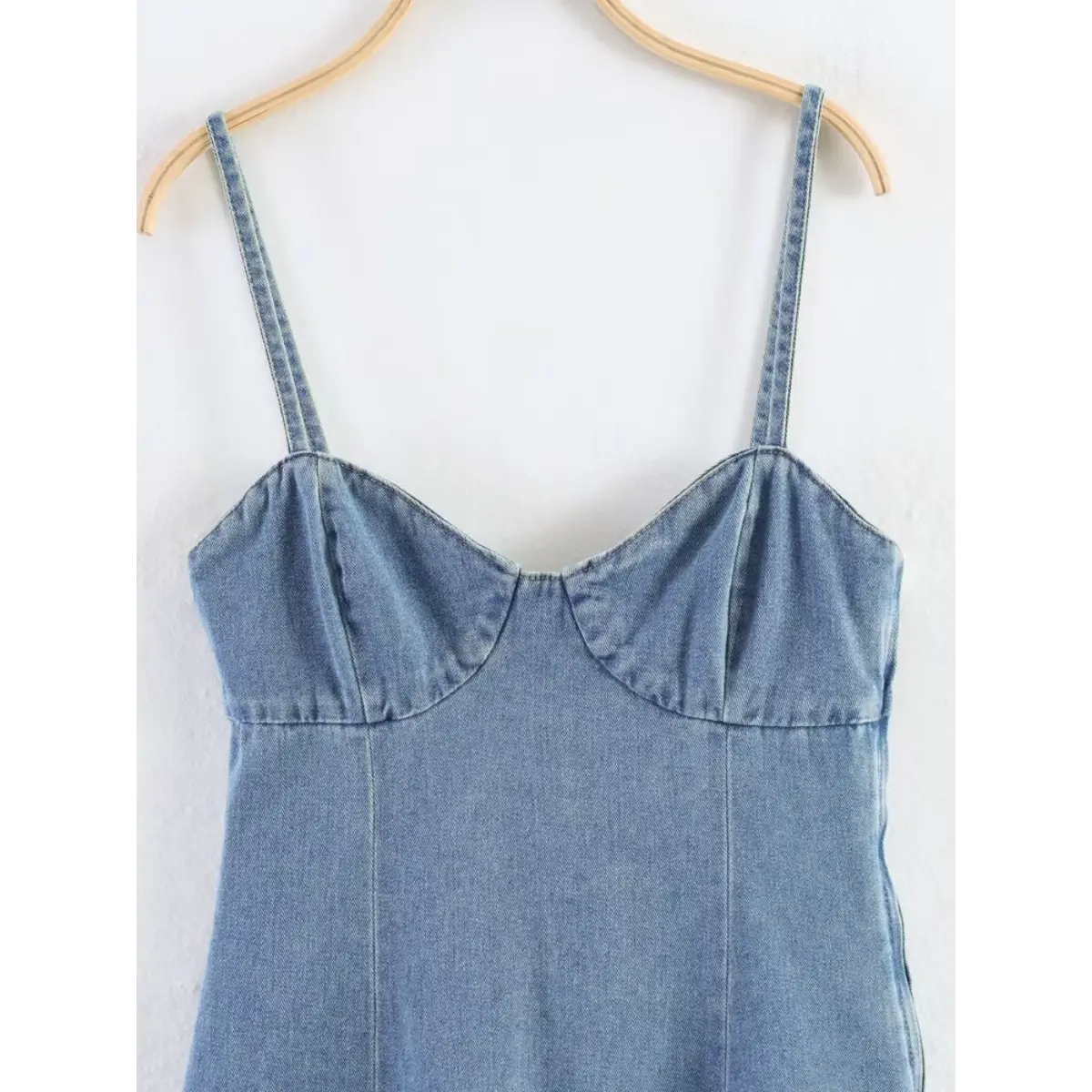 Close-up of the sweetheart neckline and bust stitching on the light blue denim cami dress