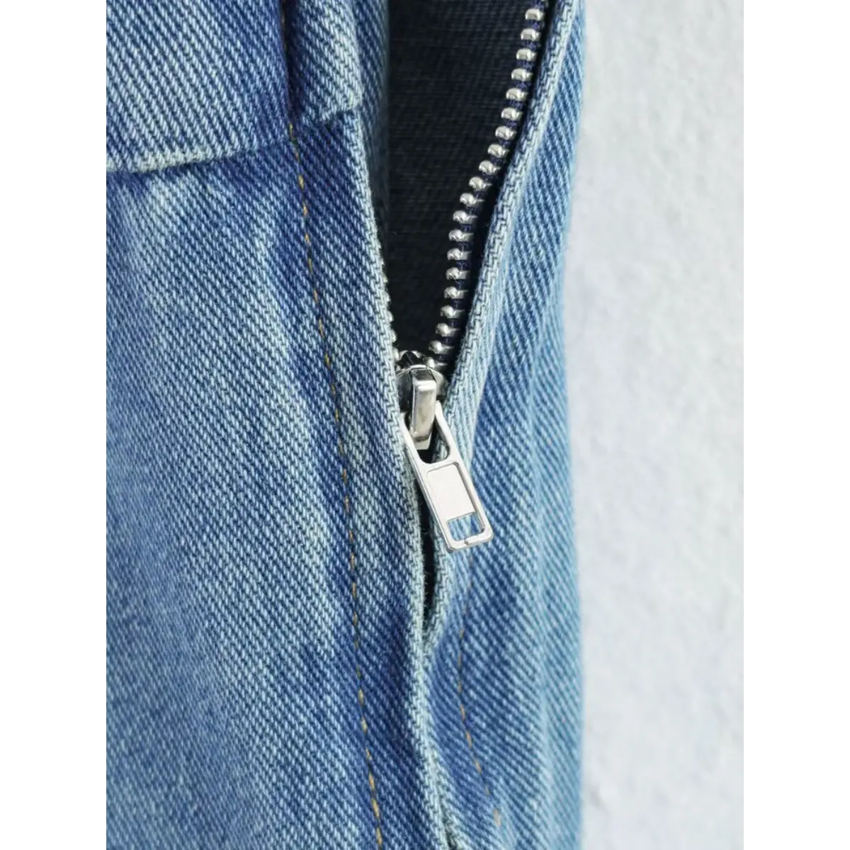 Close-up of the side metal zipper on the light blue denim cami dress