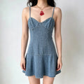 Model wearing a light blue denim camisole mini dress with a sweetheart neckline and a flared skirt.