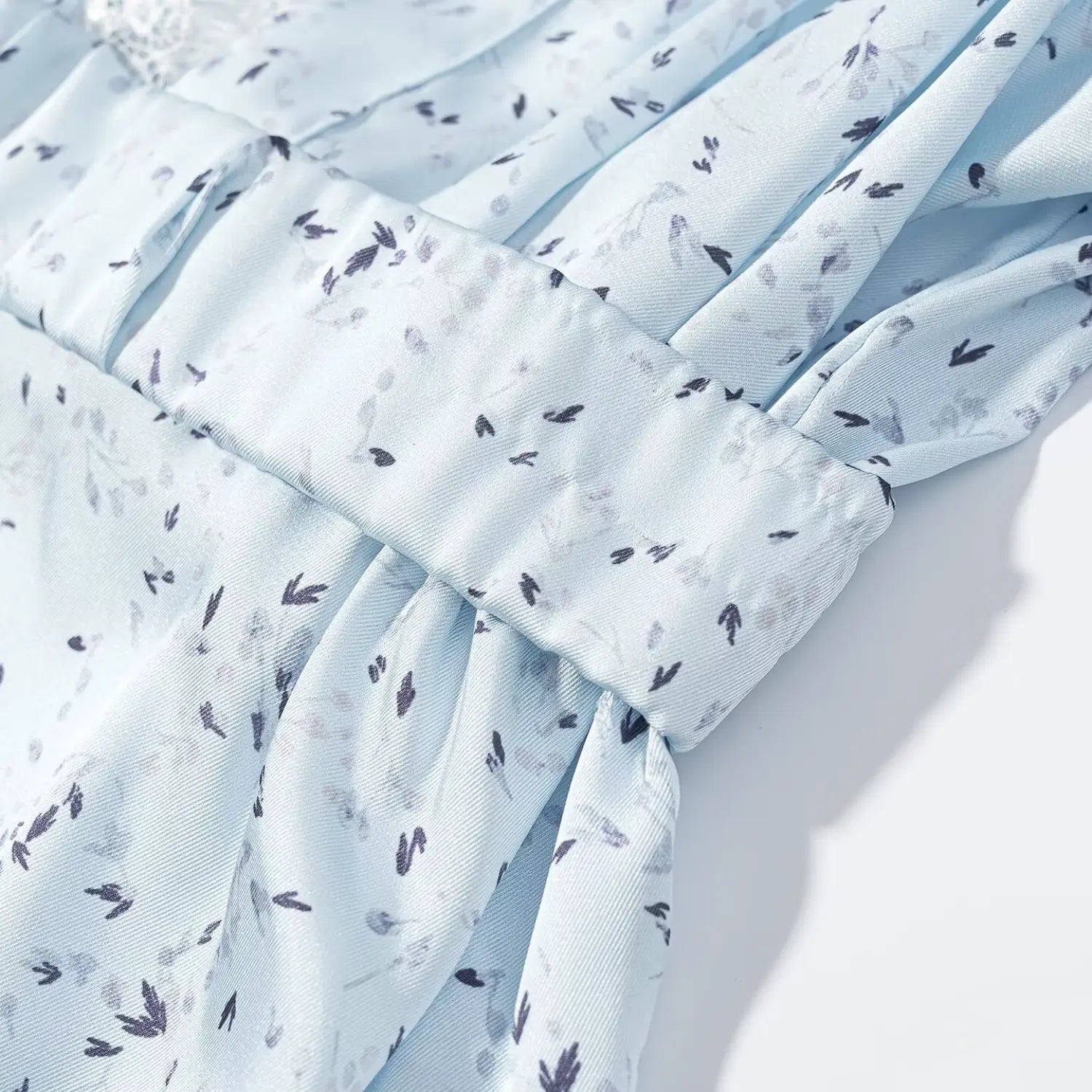 Close‑up self‑fabric matching belt waist gathering detail light blue floral maxi dress