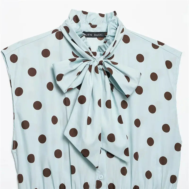 Closeup neck detail, frilled stand collar, large matching fabric bow tie, brown polka dot woven fabric