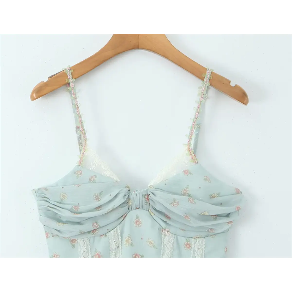Light blue floral cami dress hanging on wooden hanger, showing front bust detail