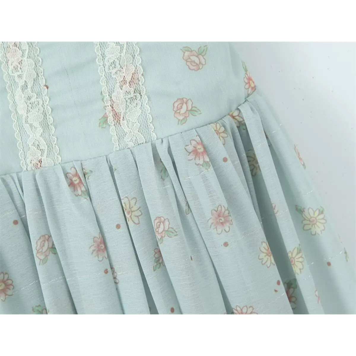Close-up of the lace-trimmed hem and vertical seam details on the light blue floral dress