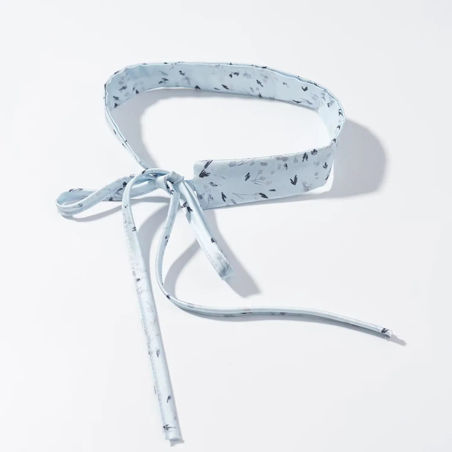 Close‑up shot detachable matching light blue ditsy floral fabric neck tie with bow knot detail